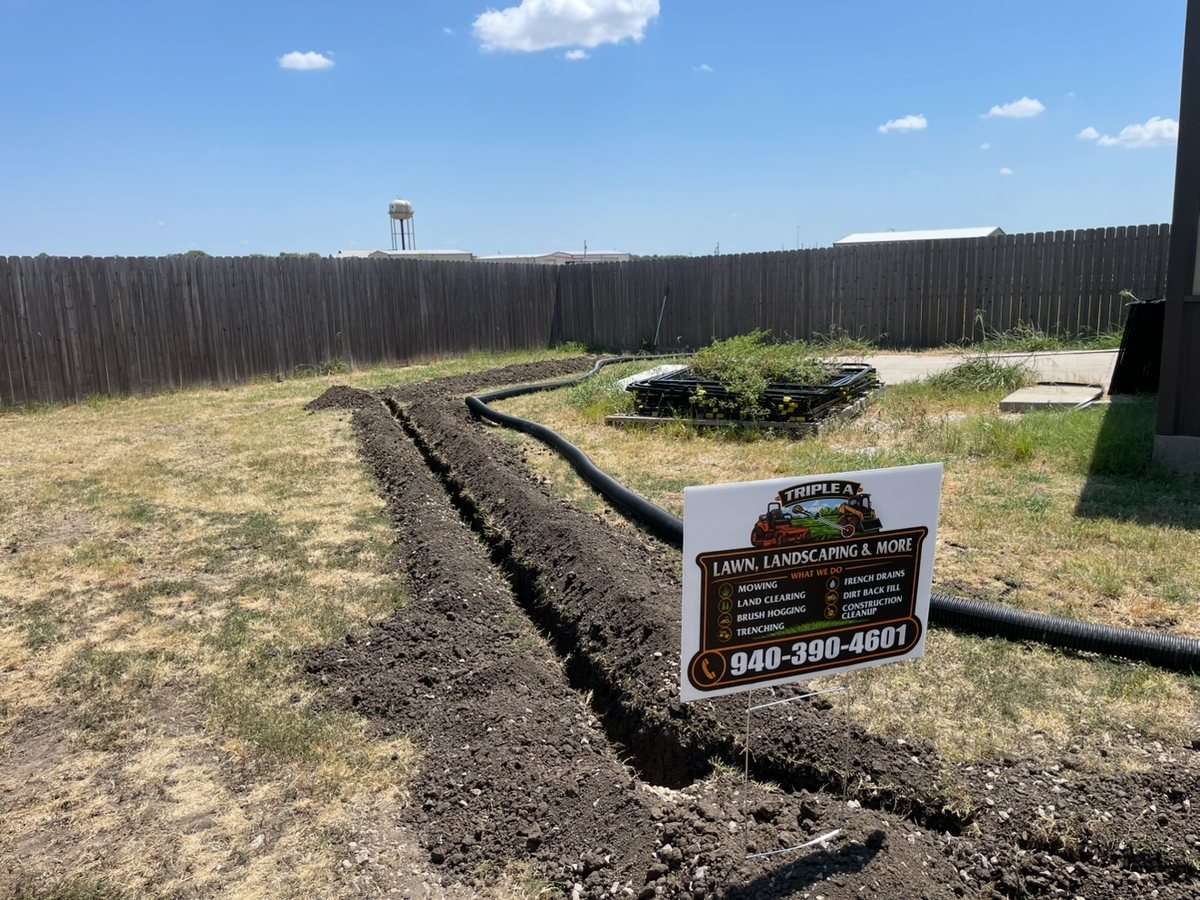 French drain trench with drain pipe installed in a residential yard