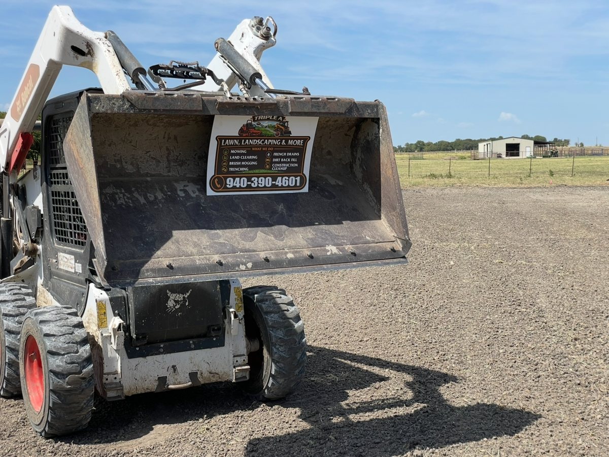 Triple A skid steer with bucket raised on a North Texas job site