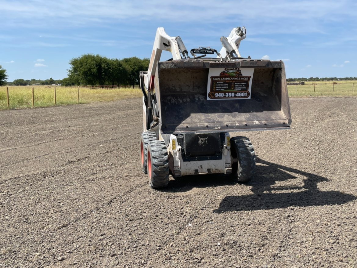 Triple A skid steer on a cleared gravel lot in North Texas